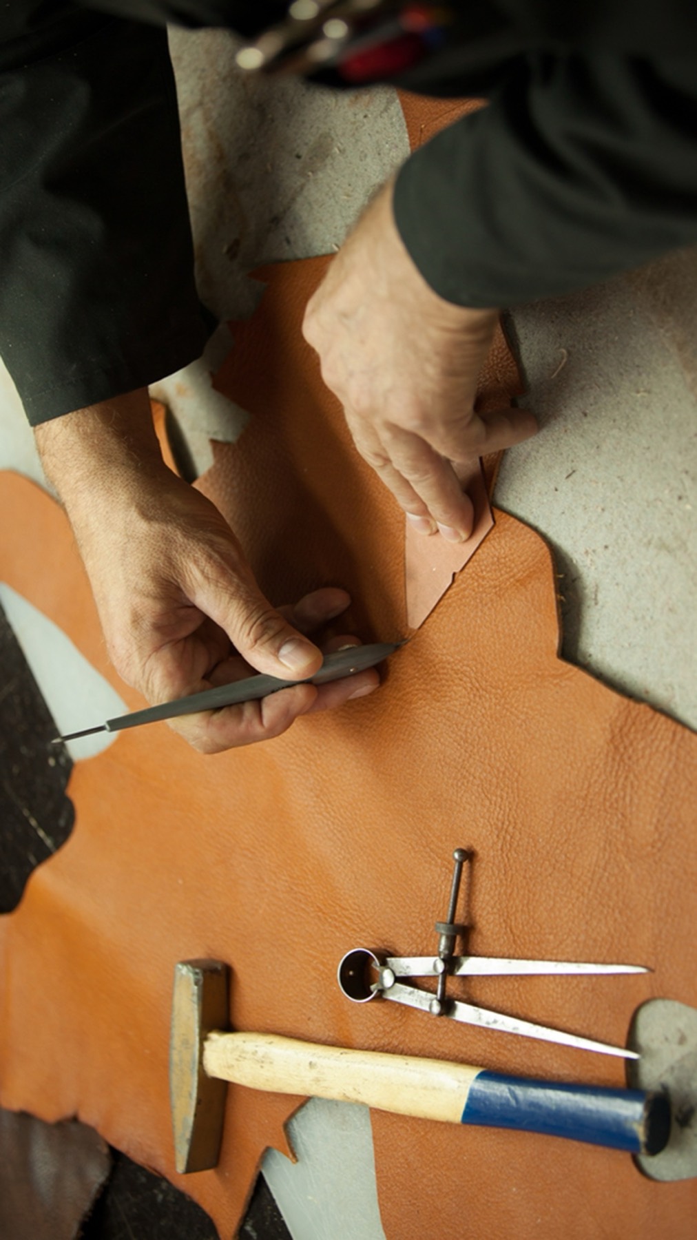 A craftsperson marking a leather hide